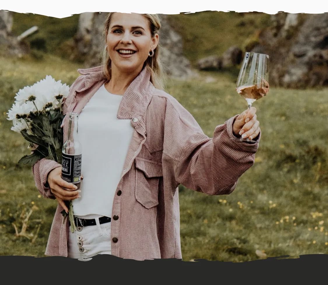 Eine Frau genießt einen Drink in einer lichtdurchfluteten Umgebung.